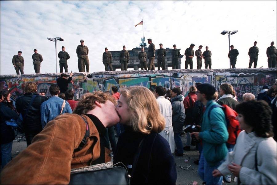 Couple Kisses In Front Of The Berlin Wall