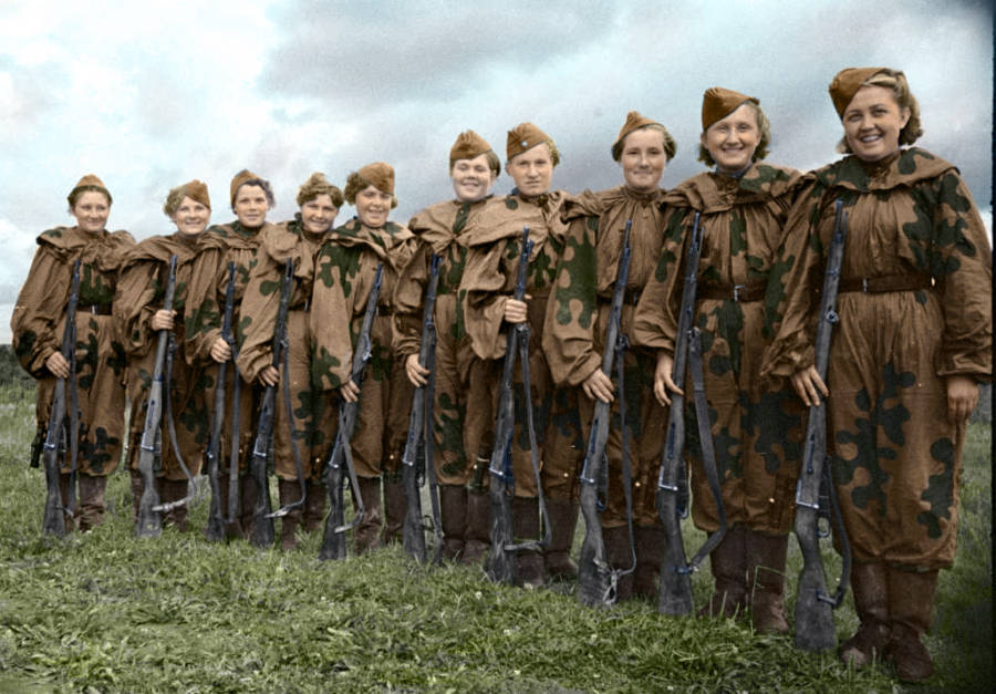 A Line Of Female Soldiers Smile While Holding Guns