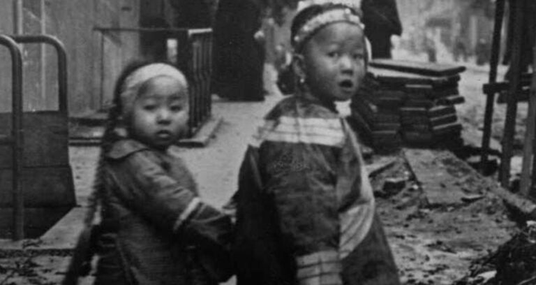 Two Children Walking In Chinatown Featured