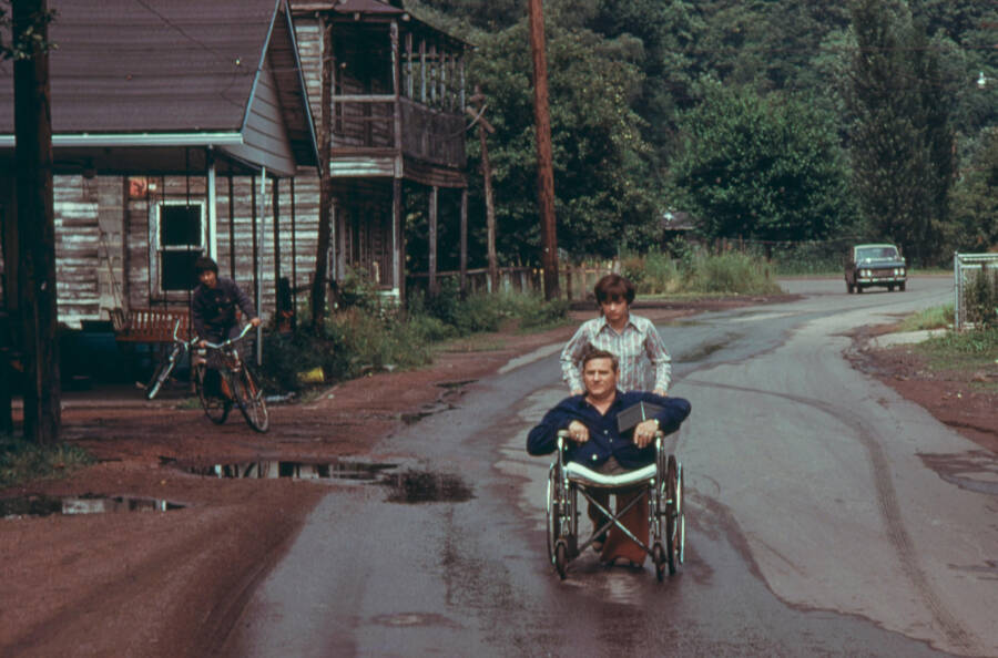 Disabled Miner Wheeled By His Daughter