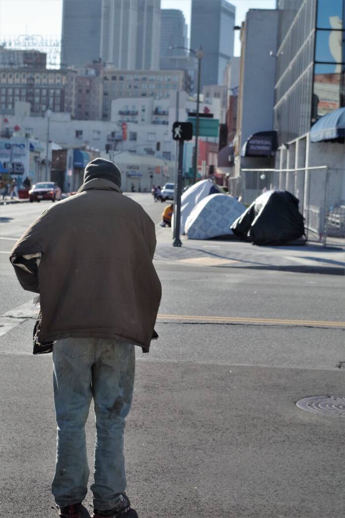 Man Crossing Street Toward Tents